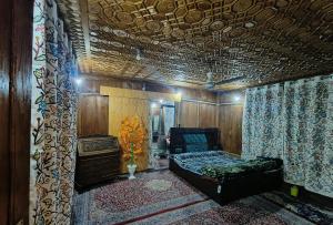 Houseboat Karima palace في سريناغار: غرفة نوم بسرير واريكة في غرفة
