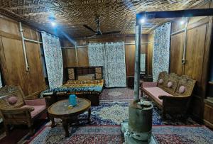 a room with chairs and a couch and a table at Houseboat Karima palace in Srinagar