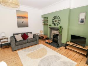 - un salon avec un canapé et une cheminée dans l'établissement 36A Mary Street, à Porthcawl