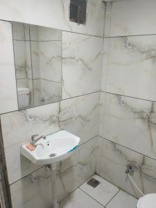 ウッジャインにあるhotel star villa residensyの洗面台と鏡のある白いバスルーム +2枚の写真