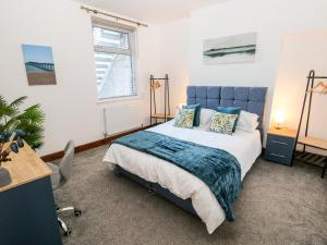 a bedroom with a blue bed and a desk at 36A Mary Street in Porthcawl