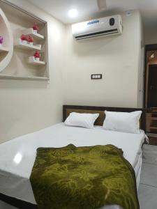 ウッジャインにあるhotel star villa residensyのベッドルーム1室(ベッド1台、壁にエアコン付)