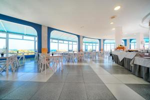 a dining room with tables and chairs and windows at Laguna Park 2 in Adeje