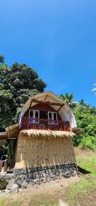 a small building with a thatched roof on top of it at homestay noah in Likupang