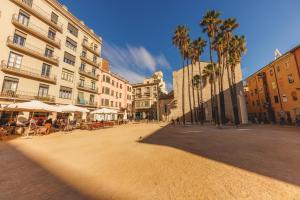 eine Straße in einer Stadt mit Palmen und Gebäuden in der Unterkunft Bravissimo Mercadal, one-bedroom plus sofa bed in Girona