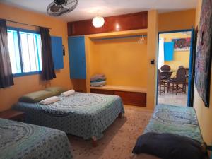 La Casa del Ritmo في إل كويو: غرفة نوم بسريرين وباب لغرفة