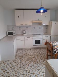 een keuken met witte kasten en een tafel en een blauw licht bij Fewo Wellnesspalast in Bad Nauheim +3 foto's