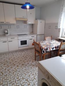 een keuken met witte apparatuur en een tafel met stoelen bij Fewo Wellnesspalast in Bad Nauheim