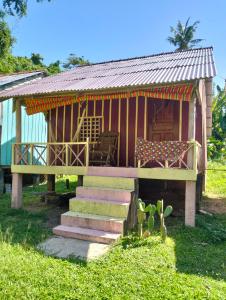 a small house with a deck and a chair at Fat Rabbit Beach Resort in Kep