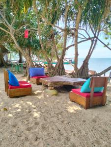 eine Gruppe Stühle und ein Tisch am Strand in der Unterkunft Fat Rabbit Beach Resort in Kep