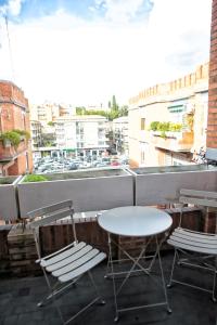 uma mesa e cadeiras numa varanda com vista para a cidade em Roma Imperial Suites em Roma
