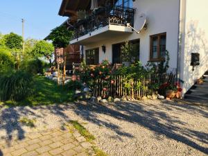 une maison avec une clôture et des fleurs dans la cour dans l'établissement Bauniglerhof, à Riedering