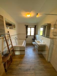 ein Badezimmer mit einer Badewanne, 2 Waschbecken und einer Badewanne in der Unterkunft Bauniglerhof in Riedering