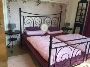 een slaapkamer met een zwart bed met roze en paarse kussens bij Bauniglerhof in Riedering