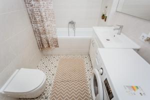 a bathroom with a toilet sink and a washing machine at Comfortable apartments. Good location. in Chişinău
