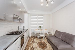 een keuken en een woonkamer met een bank en een tafel bij Comfortable apartments. Good location. in Chişinău