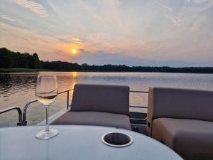 a table with two chairs and a glass of wine on a boat at Dworek Hołny in Hołny Mejera