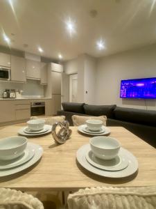 Modern & Luxury Flat في سوتون: طاولة غرفة الطعام مع أطباق وأوعية عليها