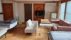 a living room with a couch and a tv at dakwan stay in Seoul