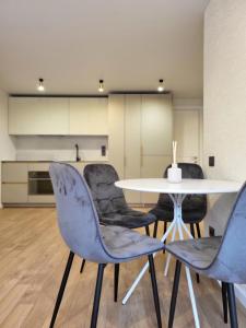 a dining room with a white table and chairs at Luna Palanga in Palanga