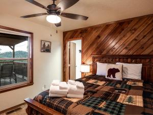 a bedroom with a bed with towels on it at Enchanted Oak Cabin in Ruidoso