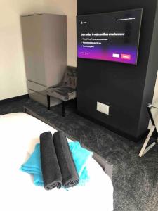 een kamer met een bed, een tv en handdoeken bij Entire 2 bed modern apartment in Nantwich