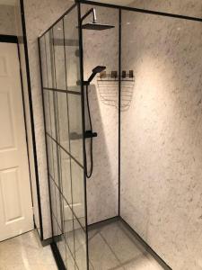 a shower with a glass door in a bathroom at Entire 2 bed modern apartment in Nantwich