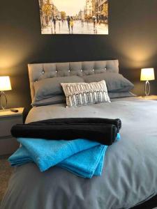 1 dormitorio con 1 cama grande y toallas azules. en Entire 2 bed modern apartment en Nantwich