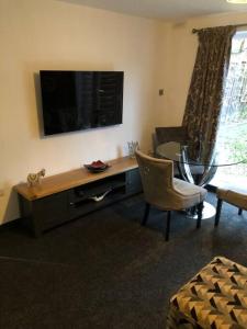 a living room with a desk and a table with a television at Entire 2 bed modern apartment in Nantwich
