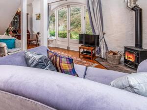 a living room with a blue couch and a fireplace at Wisteria Lodge - Qc1677 in Cilgwm