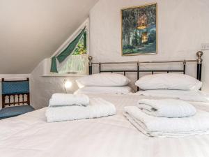 a bedroom with two beds with white towels on them at Wisteria Lodge - Qc1677 in Cilgwm
