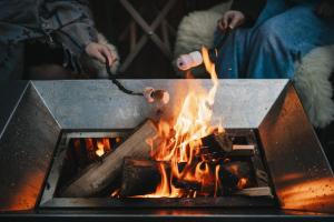una persona cocinando sobre un fuego en una parrilla en RewildThings Treehouses en Gloucester