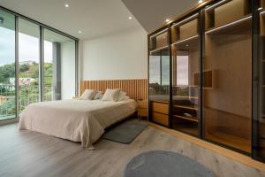 1 dormitorio con 1 cama grande y paredes de cristal en Villa 65 - City Edge Retreat en Funchal