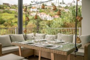 una mesa y sillas en un balcón con vistas en Villa 65 - City Edge Retreat en Funchal