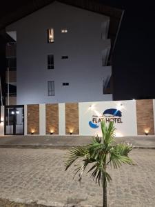 a palm tree in front of a building at night at Praia dos Carneiros Flat Hotel Lindo Apto 302 in Praia dos Carneiros