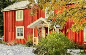 una casa roja con nieve delante en Lovely Home In Lingbo With Wifi, en Lingbo