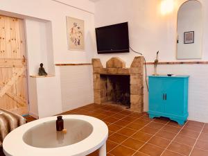 a living room with a fireplace and a tv at La Casita del Cactus - Casa de campo con piscina in Alcalá de Guadaira