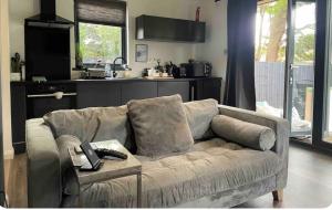 a living room with a couch and a kitchen at 1 bedroom rural cabin retreat with hot tub in Hambrook close to Bristol city centre in Bristol