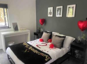 Un dormitorio con una cama con globos rojos. en 1 bedroom rural cabin retreat with hot tub in Hambrook close to Bristol city centre en Bristol