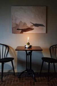 a candle sitting on a table with two chairs at Steel Hotel in Smedjebacken