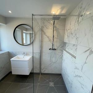 a bathroom with a shower and a sink and a mirror at Prior House Farm in Berwick-Upon-Tweed