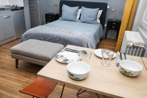 a room with a table with bowls and a bed at L' Appartement du Midi - Hyper centre Cathédrale in Angoulême