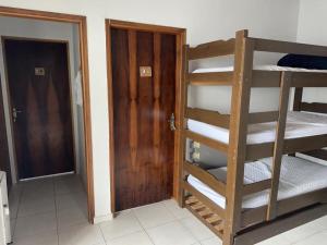 Zimmer mit 2 Etagenbetten und einer Tür in der Unterkunft Hostel Bike Point Caraguatatuba in Caraguatatuba