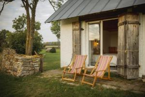 two rocking chairs sitting outside of a house at Pilguse Residency in Jõgela