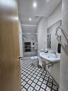 a white bathroom with a sink and a toilet at Boutique Puerta Real in Seville