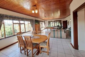 a kitchen and dining room with a table and chairs at Lovely 3 Bedroom house near the beach. in Port Edward