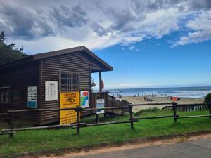 a building on the beach with the ocean in the background at Lovely 3 Bedroom house near the beach. in Port Edward