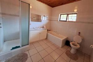 a bathroom with a shower and a toilet and a sink at Lovely 3 Bedroom house near the beach. in Port Edward +7 photos