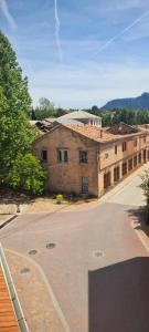 un antiguo edificio de ladrillo con un aparcamiento vacío en Apartamento Calamina, en Riópar