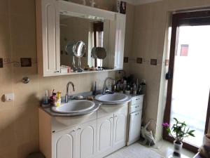 Baño con 2 lavabos y espejo en Casa Vox Torontalului, en Timisoara